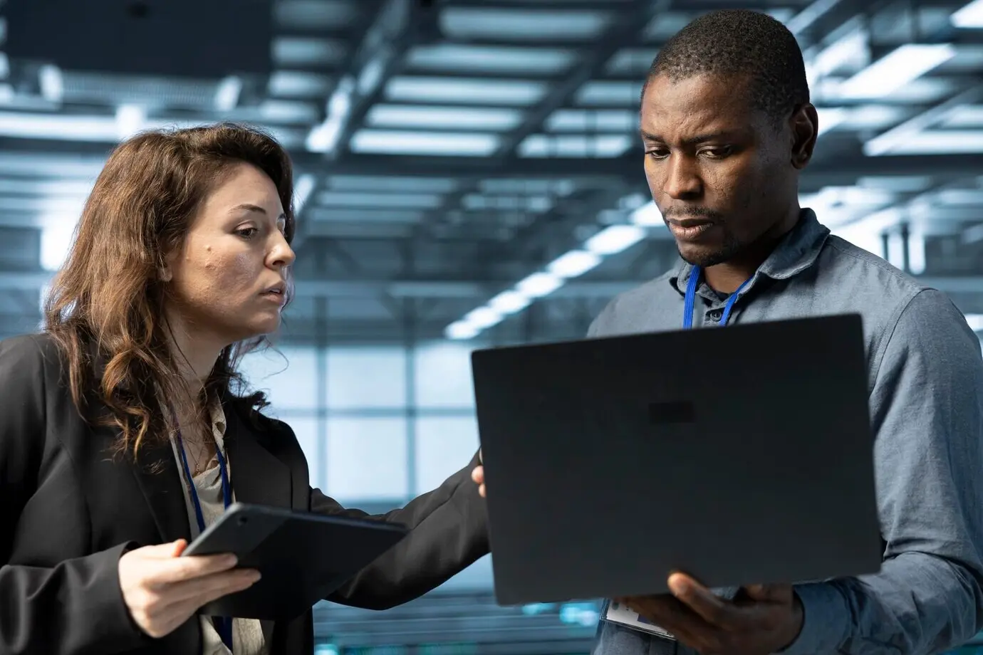 Системные администраторы используют ноутбук в центре обработки данных.