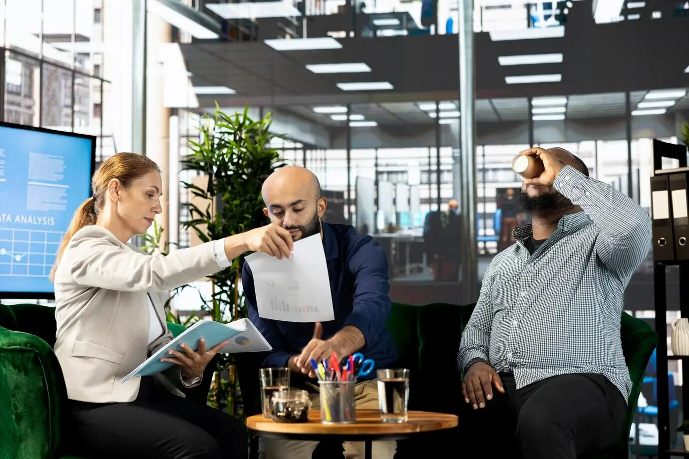 Бухгалтеры просматривают цифры выручки в документах в офисе.